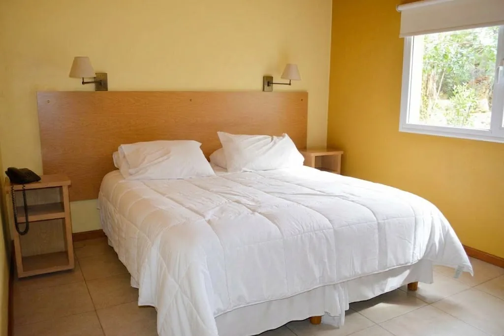 Habitación con cama grande y ventana al jardín
